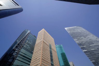 Modern şehir mimarisi, Tokyo, Japonya. Gökdelenler mavi gökyüzüne karşı güneşli bir günde 