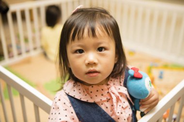 Küçük Asyalı kız oyuncakla oynuyor 