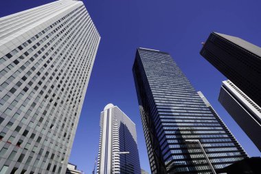 Modern şehir mimarisi, Tokyo, Japonya. Gökdelenler mavi gökyüzüne karşı güneşli bir günde 