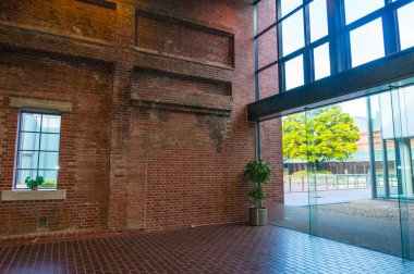 Güneş ışığı cam kapılardan tuğla döşemeye doğru akıyor.