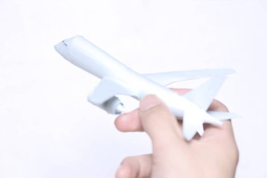 Erkek el ele tutuşan oyuncak uçak beyaz arka planda. seyahat kavramı