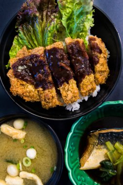 Pirinç üzerinde miso çorbası yanında gevrek katsu dinleniyor.