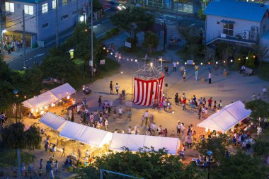 Şehirde kutlamalar yapılıyor, insanlar şehir meydanında toplanıyor. 