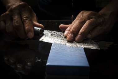 Bıçağı keskinleştiren kişinin ellerinde yakın çekim görüntüsü