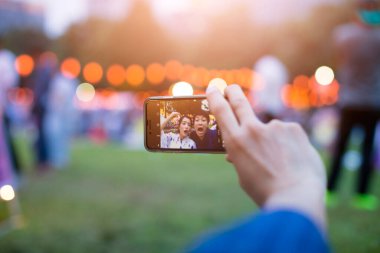 Geleneksel kimono giyen genç Japon çift parkta akıllı telefondan selfie çekiyor.