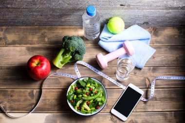 Dambıl, bir şişe su, mezura, akıllı telefon ve organik yiyecekler. sağlıklı yaşam tarzı kavramı           