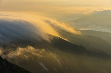 Sisli dağların üzerinde güzel gün batımı