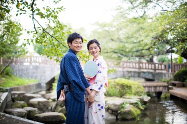 Genç Japon çift yaz parkında geleneksel kimono giyiyor.