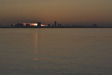 Arka planda şehir manzarası olan güzel bir gün batımı. 