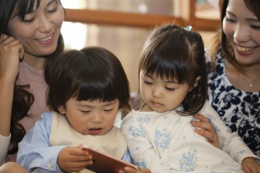 Doğumgünü partisinde çocuklu neşeli Asyalı kadınlar 