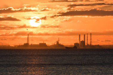 Günbatımı ve limanı olan sanayi manzarası 