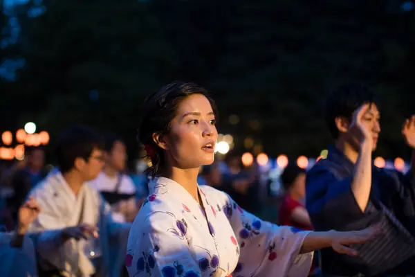 young Japanese couple wearing traditional kimono dancing in evening park