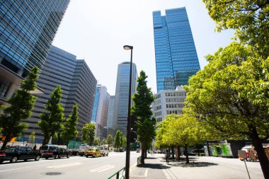 Güneşli bir günde şehir binalarının ve yeşil ağaçların manzarası 