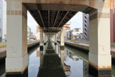 Japon şehrinde köprünün altından akan nehir.