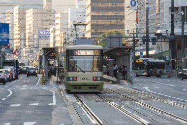 Alacakaranlık vakti kalabalık Japon şehrinden geçen tramvaylar. 
