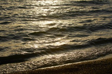 Gün batımında sahilde deniz dalgaları     