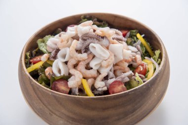 Karidesli salata, domates, deniz ürünleri ve beyaz ahşap masada marul. en üstteki görünüm.