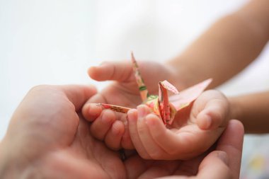 Anne ve çocuk, elinde kağıt vinç