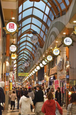 İnsanlar alışveriş alanında sokakta yürüyorlar.