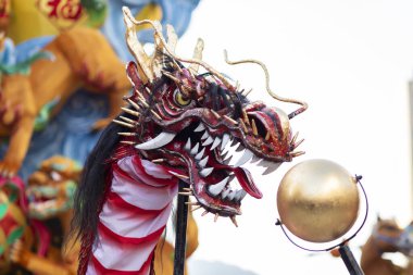 Mavi gökyüzü arka planında Çin Yeni Yıl Ejderhası Madalyası. Çin heykel tasarımları. Ejderha kafası. - Mutlu yıllar. Festivalsel arka planda Ejderha Dekorasyonu.