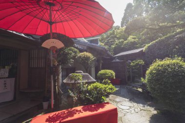 Japonya 'nın Nagasaki kentindeki Shindenan Hermitage girişinde geleneksel Japon bahçesine sahip kırmızı şemsiye. 