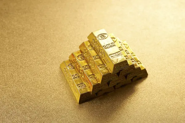 stack of gold bars on yellow background