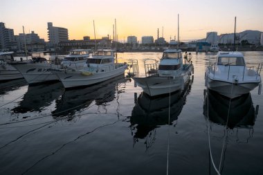 Deniz limanına demirlemiş teknelerin gün batımı manzarası