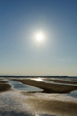 Kumsalda gün batımı ve mavi gökyüzü