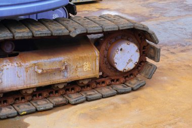 Kapalı çekim, beton yüzeyde dinlenen paslı kazıcı izlerini gösteriyor.