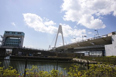 Modern kablo, parlak mavi gökyüzünün altında nehir boyunca uzanan köprü olarak kaldı