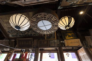 İçerideki ahşap tavandan sarkan dekoratif fenerler.