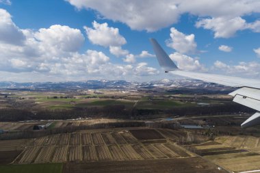 Kara ve uçak kanadının havadan görüntüsü. Gökyüzünde bir uçak.