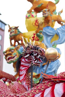 Mavi gökyüzü arka planında Çin Yeni Yıl Ejderhası Madalyası. Çin heykel tasarımları. Ejderha kafası. - Mutlu yıllar. Festivalsel arka planda Ejderha Dekorasyonu.