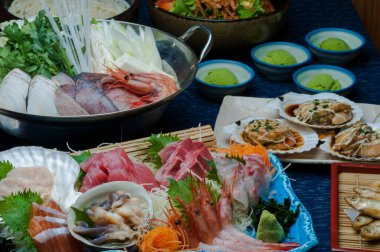 Japon mutfağı. Masada çeşitli yemekler var. Deniz mahsullü saşimi.