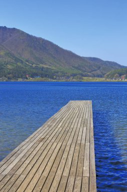 Göl ve dağlardaki ahşap iskelenin güzel manzarası. 