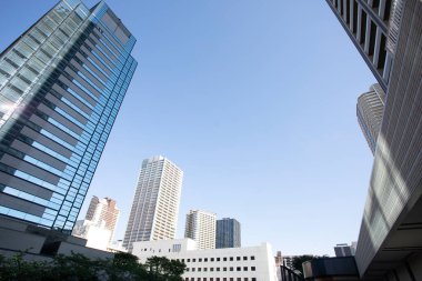 Güneşli bir günde modern şehir mimarisi. Mavi gökdelenlere karşı şehrin manzarası