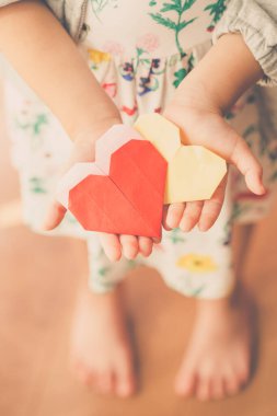 Kağıt kalp tutan çocuğun elleri