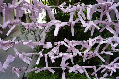 Katlanmış kağıt dilekleri Japonya, Kyoto 'da iyi şans ve refah için tapınağın dışındaki yatay tellere bağlı.