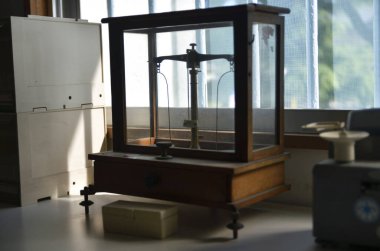 Laboratuvarda pencerenin yanına antika denge terazisi yerleştirildi