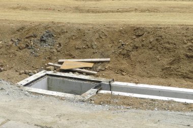 İnşaat sırasında toprak yolun yanında beton drenaj yapısı
