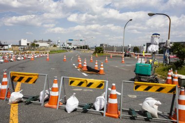 Turuncu trafik konileri güneşli bir günde boş yolu tıkıyor