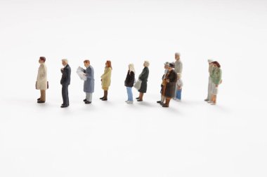 Hafif arka planda minyatür insanlar var. İnsan heykelcikleri maket yapar