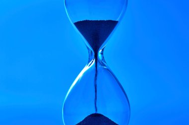 İçinde kum olan kum saatinin yakın görüntüsü.