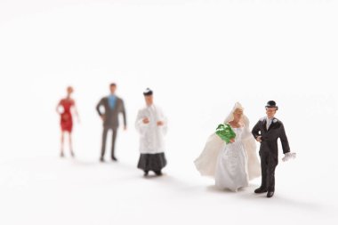 Beyaz arka planda gelin ve damadın küçük figürleri      