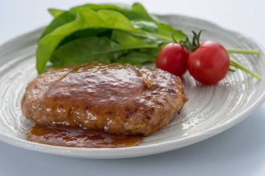 Domatesli ızgara biftek, salata yaprağı ve sos.