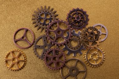 Altın desenli arka planda çeşitli metal dişlileri