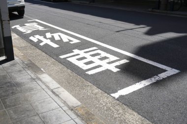 Günışığı Japon caddesinde beyaz yol işaretleri var.
