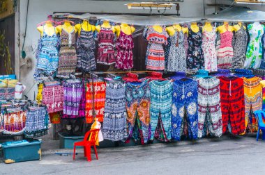 Sokak pazarındaki askılarda gösterilen renkli giysiler