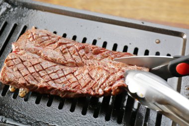 Izgarada taze biftek pişiriyorum.