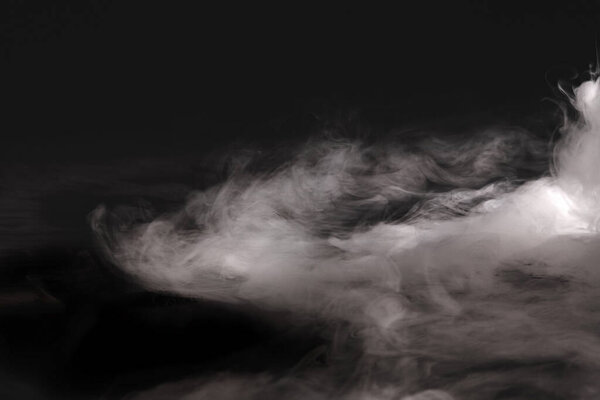 white smoke in the dark background. abstract texture of fog.                   
